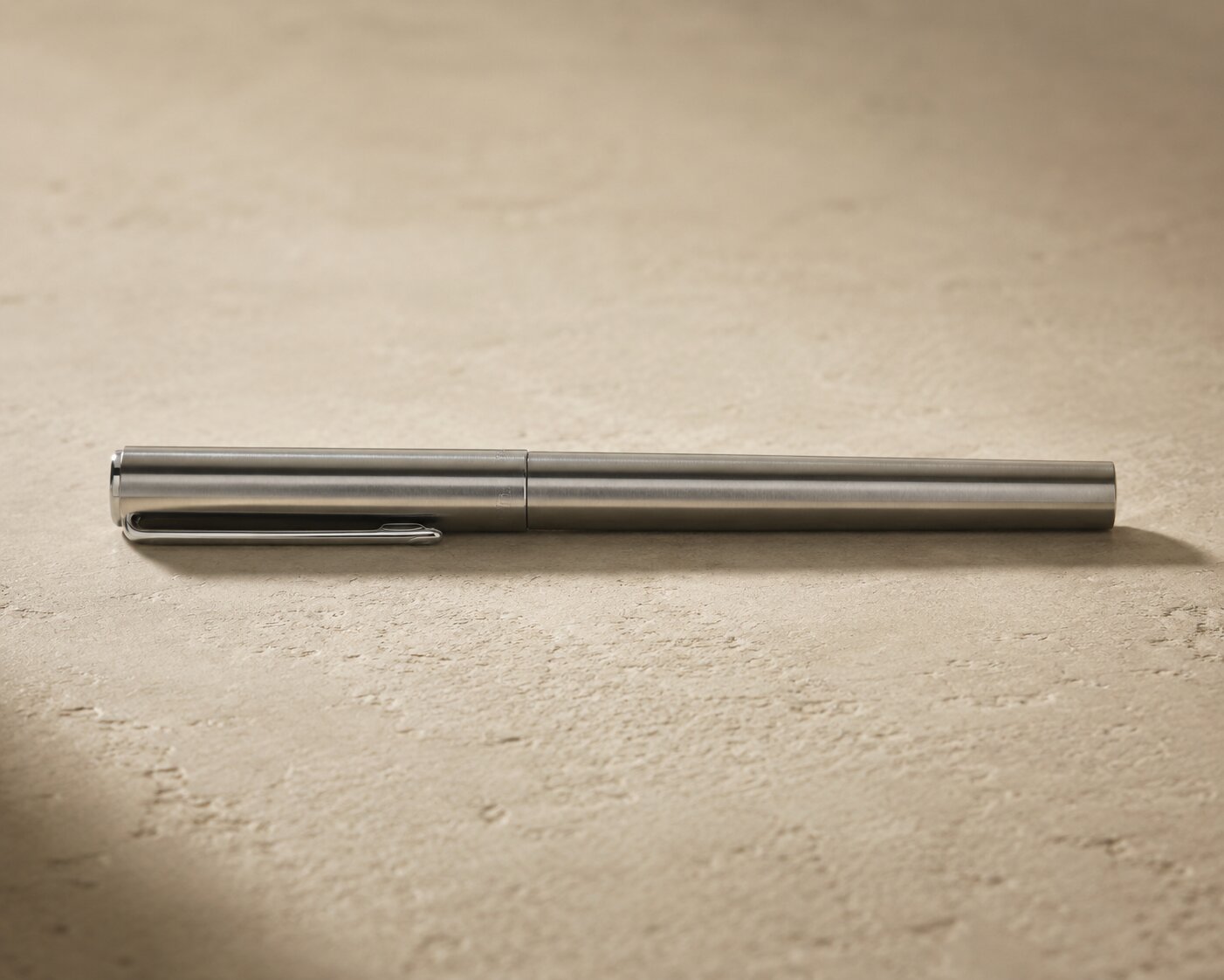 TETSU pen resting on a surface showing its slim balanced form